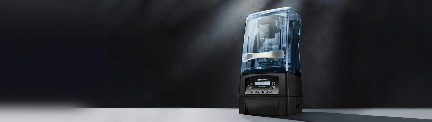 Vitamix The Quiet One commercial blender with its sound cover on a dark studio background