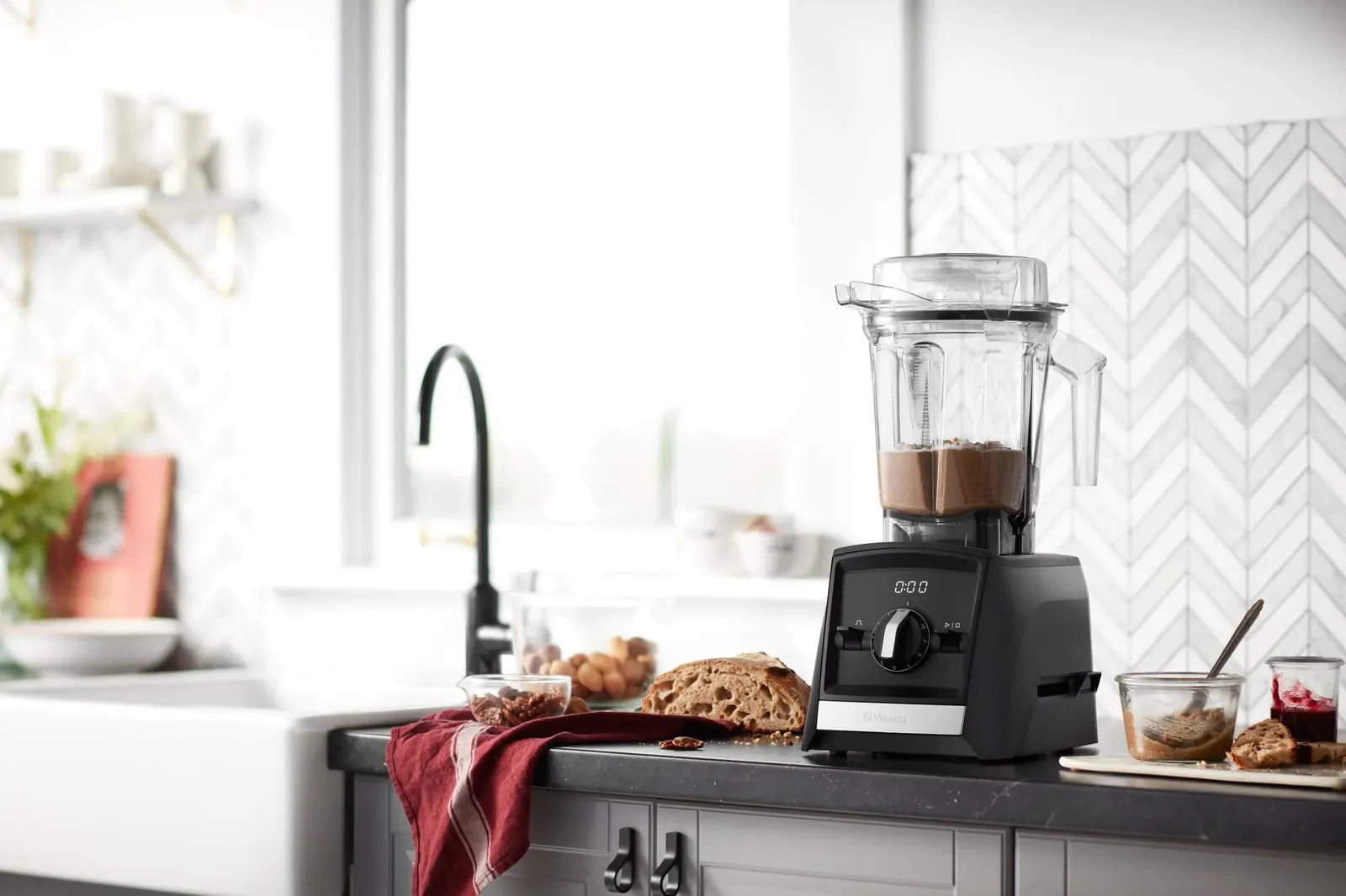 A Vitamix Ascent A2300i making nut butter on a bright home kitchen bench